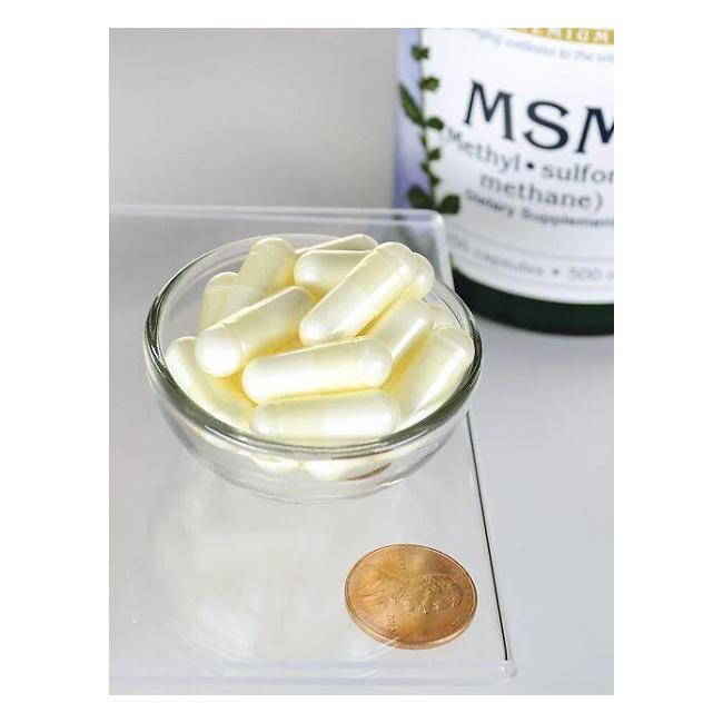 A glass bowl of white capsules sits on a countertop next to a penny, with a background bottle labeled "Swanson MSM 500 mg 250 Capsules," highlighting its organic sulfur compound, methylsulfonylmethane.