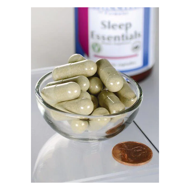 A small glass bowl of green capsules sits beside a penny for scale. A bottle labeled "Swanson Sleep Essentials Includes GABA and Melatonin 60 Veggie Capsules" is partially visible, offering natural sleep support for your nightly routine.