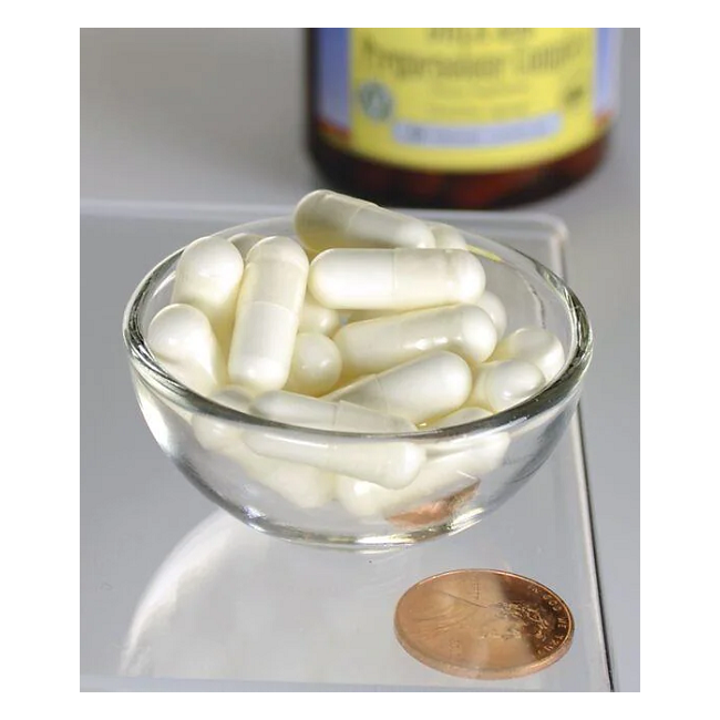 A glass bowl with Swanson DHEA 25 mg & Pregnenolone 100 mg veggie capsules sits next to a penny, highlighting hormonal balance. A bottle with a yellow label is in the background.