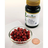 Imagen en miniatura de un frasco de Swanson Beta-Carotene - 10000 IU 250 softgels dietary supplement with a penny next to it.