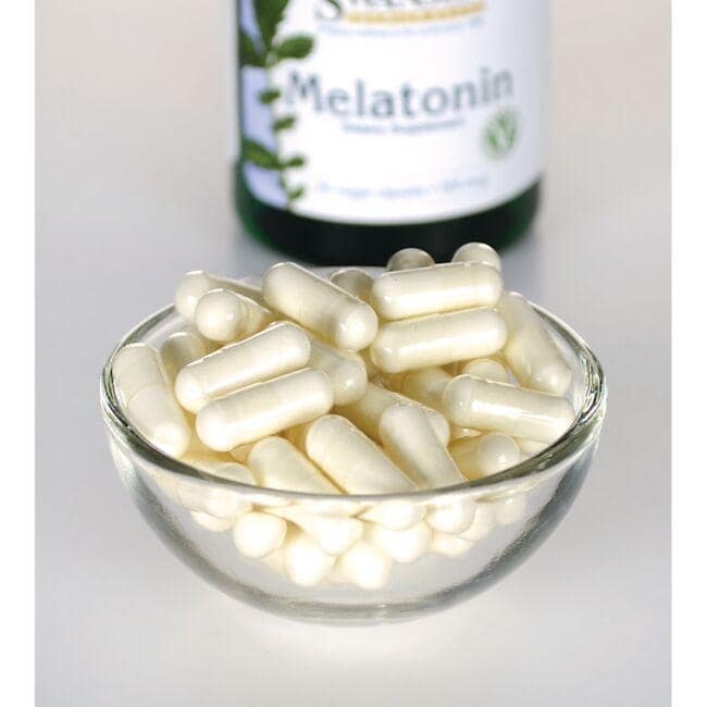 Swanson Melatonina - 0,5 mg 60 cápsulas vegetales en un recipiente de cristal junto a una botella.