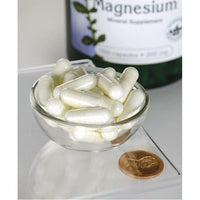 Miniatura de Swanson Óxido de magnesio - 200 mg 500 cápsulas en un cuenco junto a una botella.