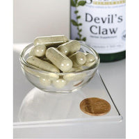 Miniatura de Swanson's Devil's Claw - 500 mg 100 cápsulas en un cuenco con una moneda.