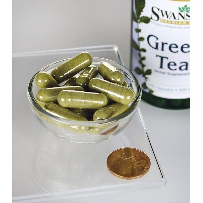 Un frasco de Swanson Té Verde - 500 mg 100 cápsulas con un céntimo al lado.