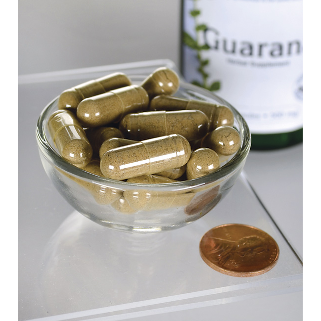 Swanson Guaraná - 500 mg 100 cápsulas en un cuenco junto a una botella.
