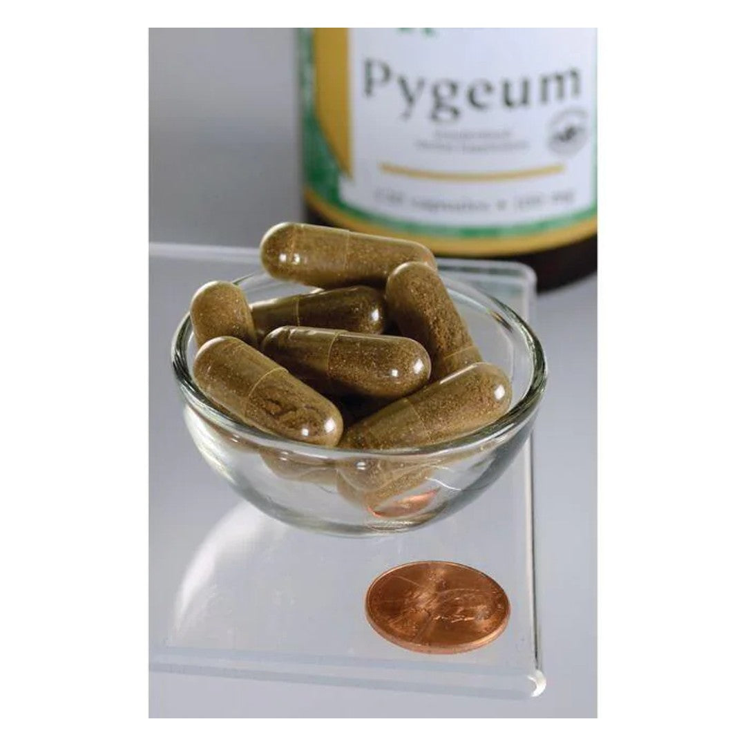 Swanson Corteza y Extracto de Pygeum - 120 cápsulas en un cuenco junto a un penique, favorecen la salud de la próstata.