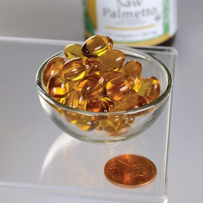 Un cuenco de Swanson Saw Palmetto - 160 mg 120 softgel junto a un céntimo, que promueve la salud de la próstata.