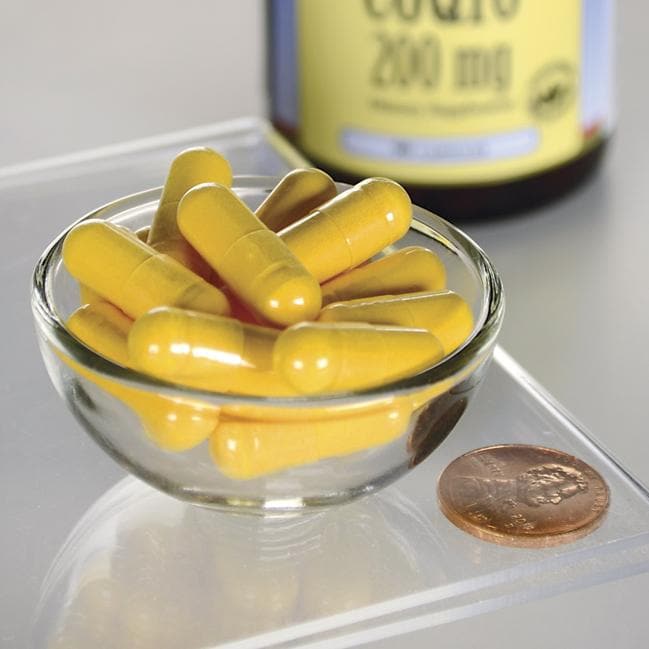 Swanson Coenzima Q10 - 200 mg 90 cápsulas en un cuenco junto a un penique.