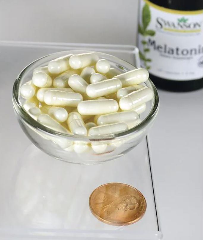 Un cuenco de Swanson Melatonina - 3 mg 120 cápsulas junto a un céntimo.